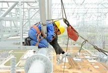 Construction workers are installing overhead power lines at a height
